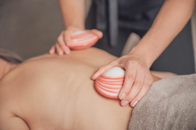 Körpermassage, Hot Lava Shell, Venusmuscheln, Frau, Entspannen, Spa, Copyright AdobeStock_583567309